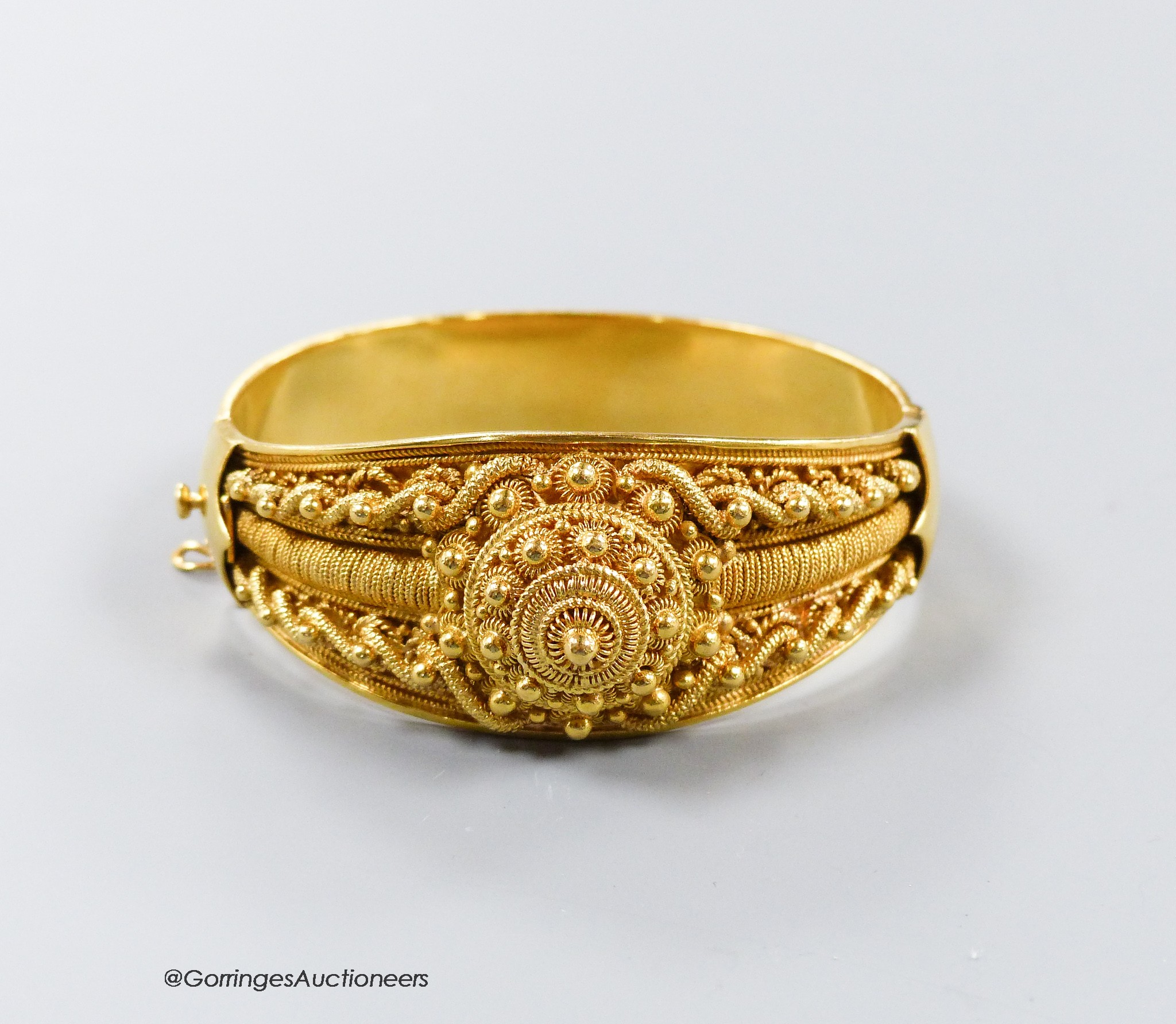 A 20th century Victorian style yellow metal (stamped 19k) cannetile work hinged bracelet, interior diameter 57mm, 60.1 grams.